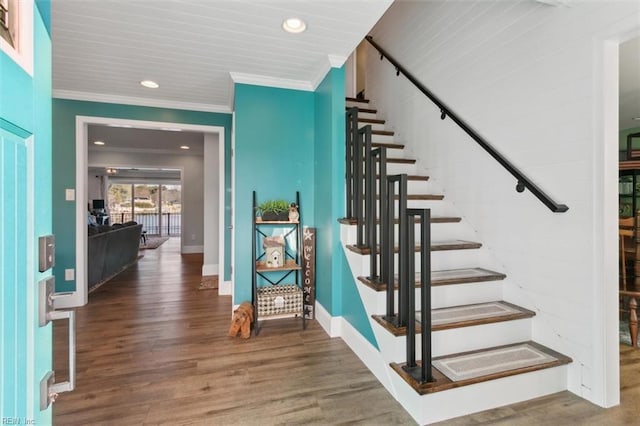 stairway with hardwood / wood-style flooring and crown molding