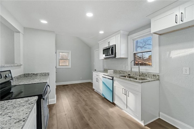 kitchen featuring sink, a healthy amount of sunlight, light stone counters, white cabinets, and appliances with stainless steel finishes