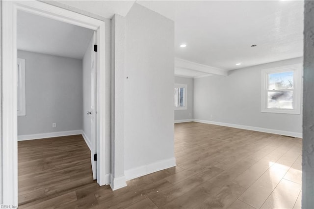 unfurnished room with beamed ceiling and dark hardwood / wood-style flooring