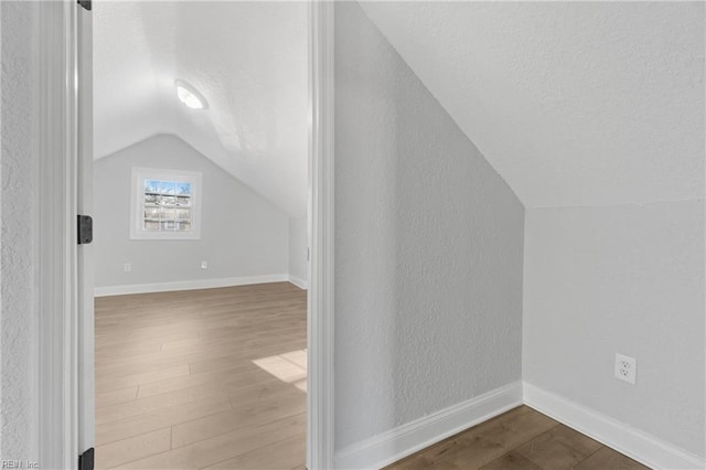 bonus room featuring vaulted ceiling and hardwood / wood-style flooring