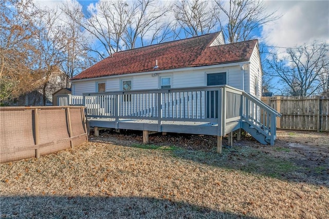 rear view of property with a storage shed and a deck