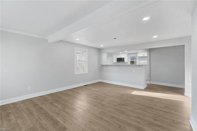 unfurnished living room featuring wood-type flooring and crown molding