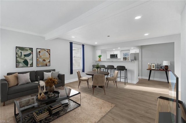 living room with beam ceiling and light hardwood / wood-style flooring