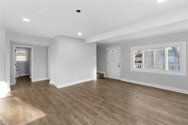 unfurnished living room with crown molding and dark hardwood / wood-style flooring