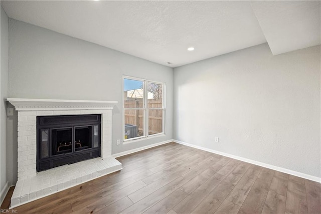 unfurnished living room featuring a fireplace and wood-type flooring