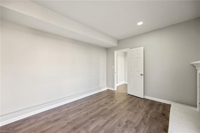 basement with a fireplace and wood-type flooring