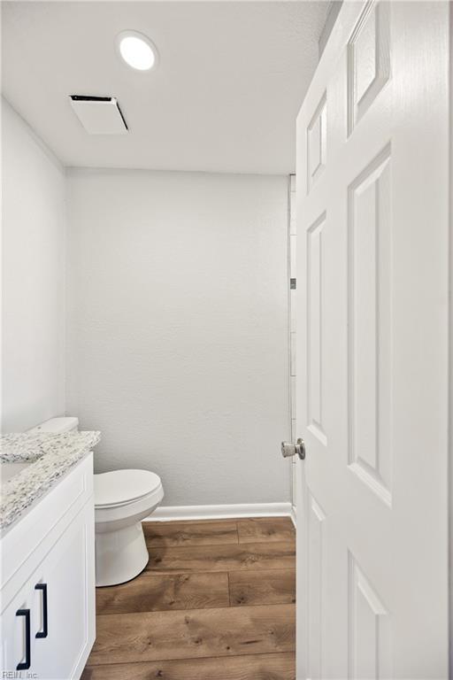 bathroom featuring vanity, toilet, and wood-type flooring