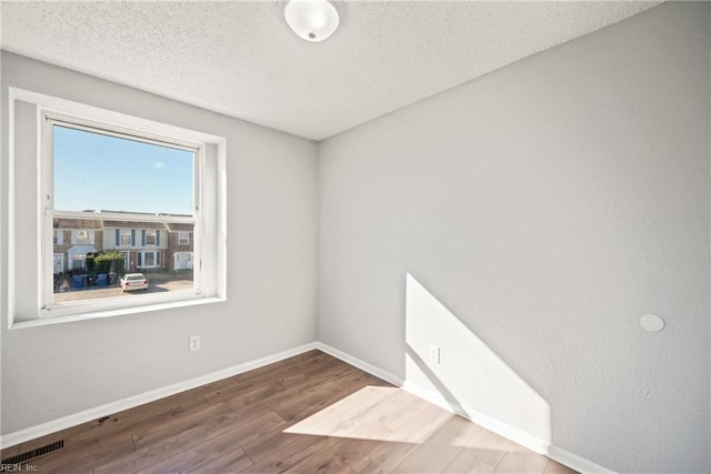 spare room with wood-type flooring and a textured ceiling