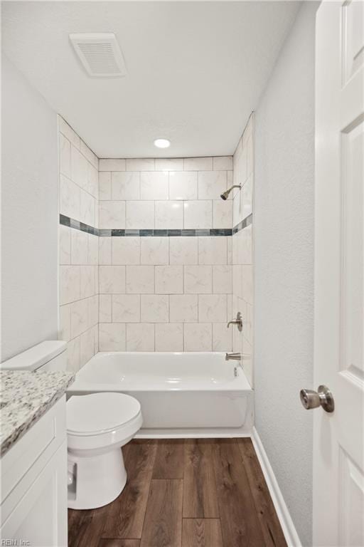 full bathroom with vanity, tiled shower / bath combo, and toilet