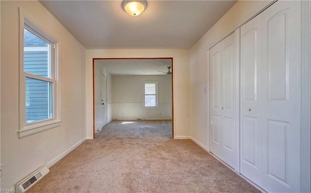 hall featuring light carpet and a healthy amount of sunlight