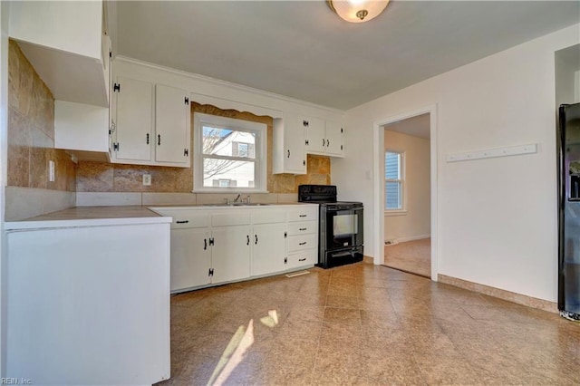 kitchen featuring tasteful backsplash, sink, refrigerator with ice dispenser, electric range, and white cabinets