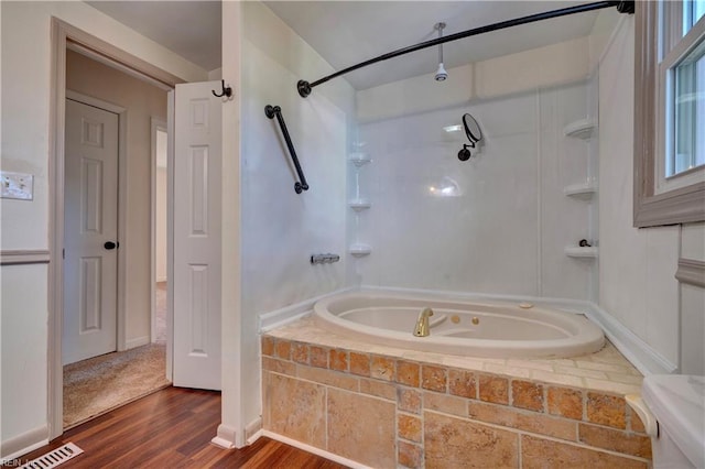 bathroom with hardwood / wood-style flooring and tiled shower / bath combo