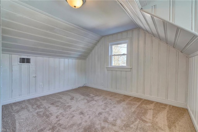 additional living space with light carpet and vaulted ceiling