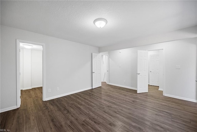 unfurnished room with a textured ceiling and dark wood-type flooring