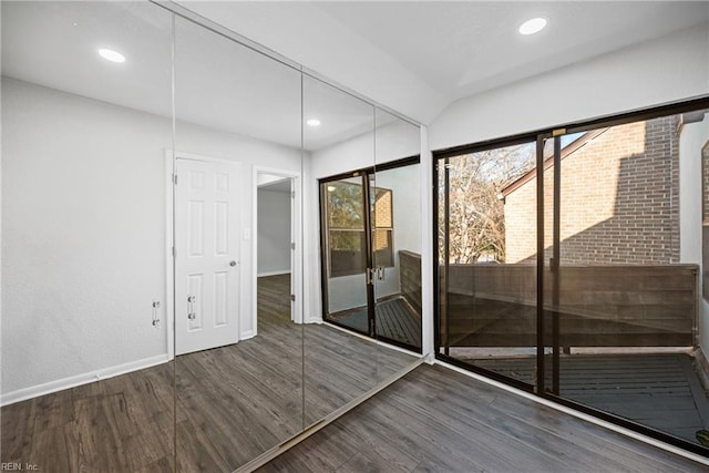 interior space featuring dark wood-type flooring and vaulted ceiling