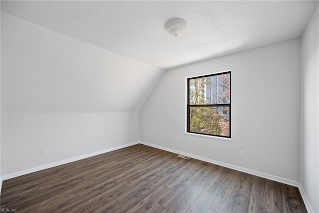 additional living space with lofted ceiling and dark hardwood / wood-style floors