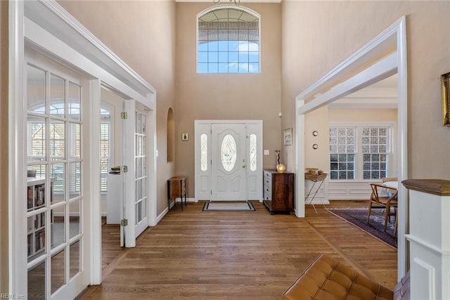 entryway with hardwood / wood-style flooring, a high ceiling, and french doors