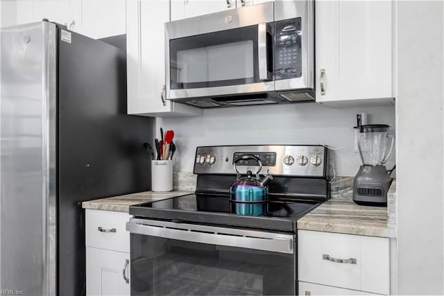 kitchen with white cabinetry and appliances with stainless steel finishes