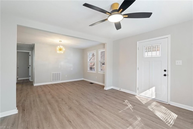 foyer featuring ceiling fan with notable chandelier and light wood-type flooring