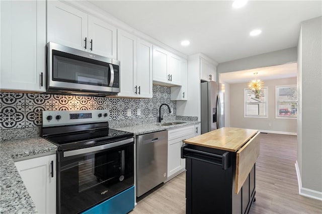 kitchen featuring white cabinetry, light stone countertops, and appliances with stainless steel finishes