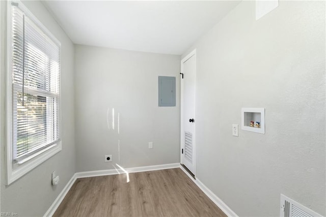 laundry area with electric dryer hookup, electric panel, hookup for a washing machine, and light hardwood / wood-style floors