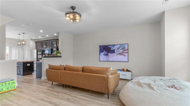 living room featuring light hardwood / wood-style floors and an inviting chandelier