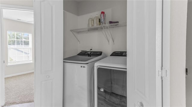 clothes washing area with washer and dryer and light colored carpet