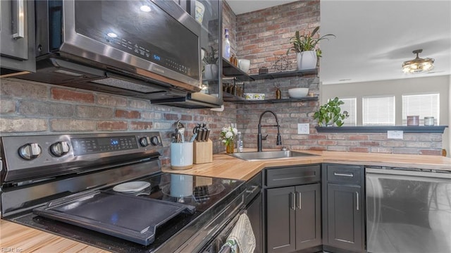 kitchen with hardwood / wood-style flooring, sink, wooden counters, and appliances with stainless steel finishes