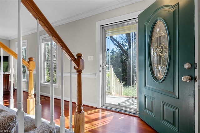 doorway to outside with crown molding, plenty of natural light, and hardwood / wood-style floors