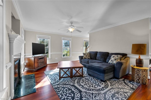 living room with crown molding, a high end fireplace, dark hardwood / wood-style floors, and ceiling fan