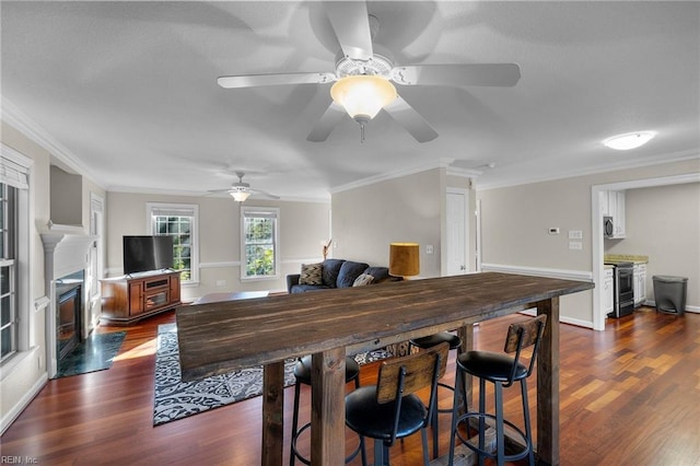 dining space with ceiling fan, dark hardwood / wood-style flooring, and ornamental molding