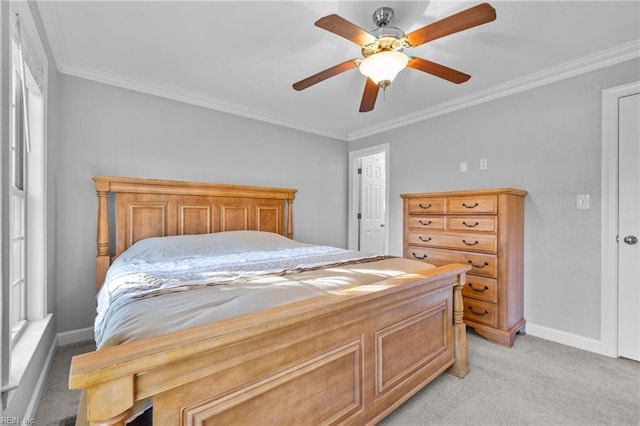 carpeted bedroom with ceiling fan and ornamental molding