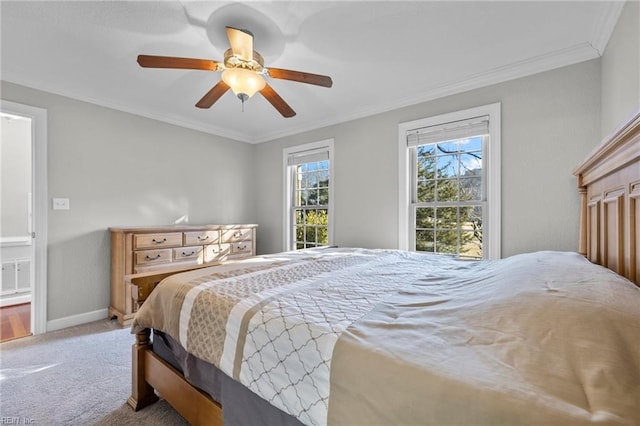 carpeted bedroom featuring ceiling fan and crown molding