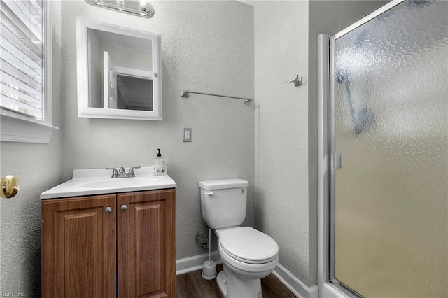 bathroom featuring vanity, toilet, wood-type flooring, and walk in shower