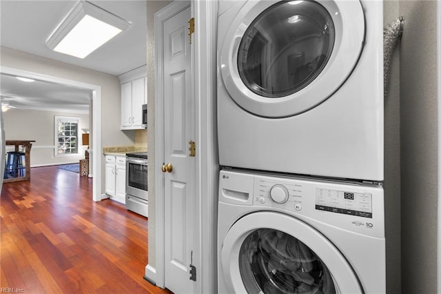 clothes washing area featuring ceiling fan, dark hardwood / wood-style floors, and stacked washer / drying machine