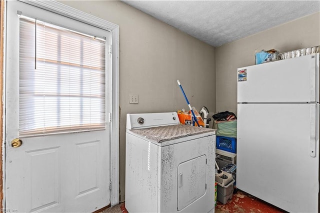 laundry room with a textured ceiling and washer / dryer