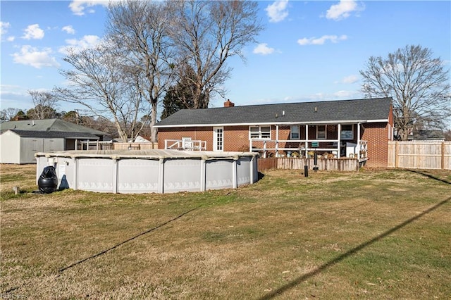 back of house featuring a lawn and a covered pool