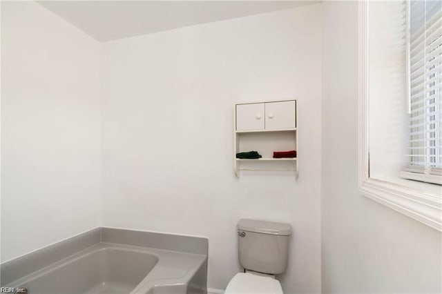 bathroom featuring a bath and toilet