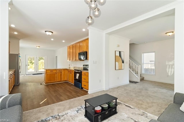 kitchen featuring kitchen peninsula, carpet floors, ornamental molding, and appliances with stainless steel finishes