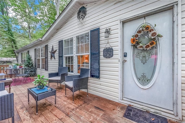 view of exterior entry featuring an outdoor hangout area and a deck