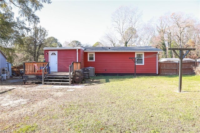 rear view of house featuring a lawn and a wooden deck