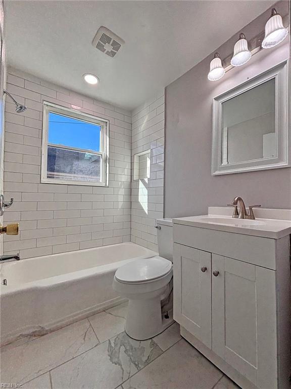 full bathroom featuring vanity, toilet, and tiled shower / bath