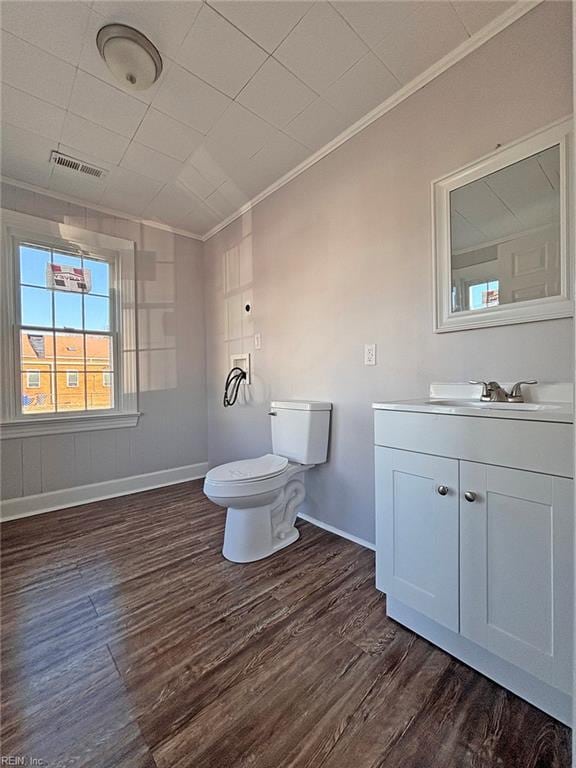 bathroom with crown molding, vanity, wood-type flooring, and toilet