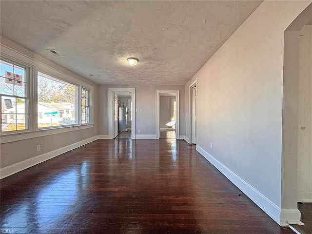 empty room featuring dark wood-type flooring and a textured ceiling