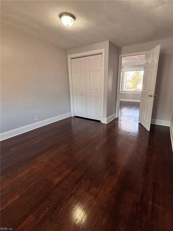 unfurnished bedroom featuring dark hardwood / wood-style flooring, a closet, and a textured ceiling