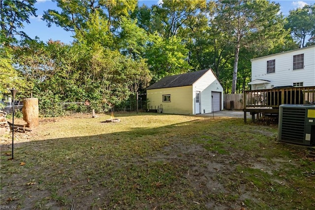 view of yard featuring an outdoor structure, a wooden deck, central AC unit, and a garage