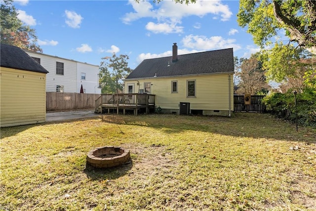 back of property featuring central air condition unit, a yard, a deck, and an outdoor fire pit