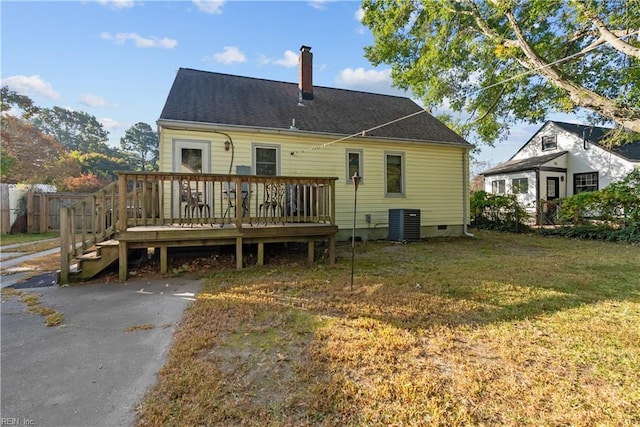 rear view of house featuring a lawn and a wooden deck