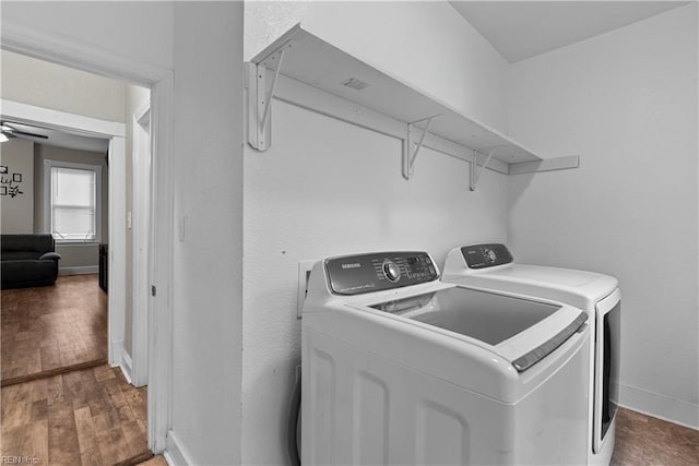 laundry area with separate washer and dryer, ceiling fan, and hardwood / wood-style floors