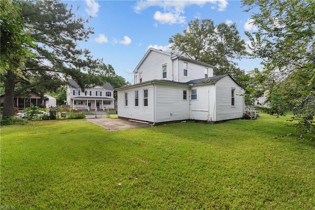 rear view of house with a lawn and a patio area